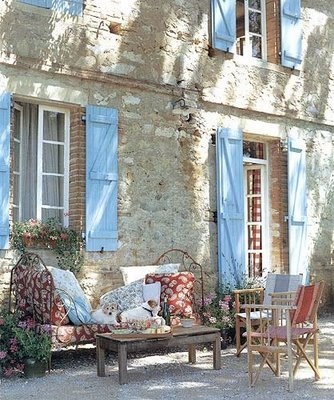 French country daybed with local Provençal fabrics: an inviting spot to take refuge from the heat of the day, near the stone walls of an old country house in Provençe.: 